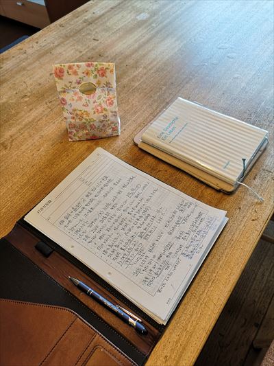 設計面談の画像　テーブルにノートと手帳と頂いた焼き菓子