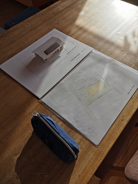 住宅計画の打ち合わせテーブルに置かれた計画図と模型の画像